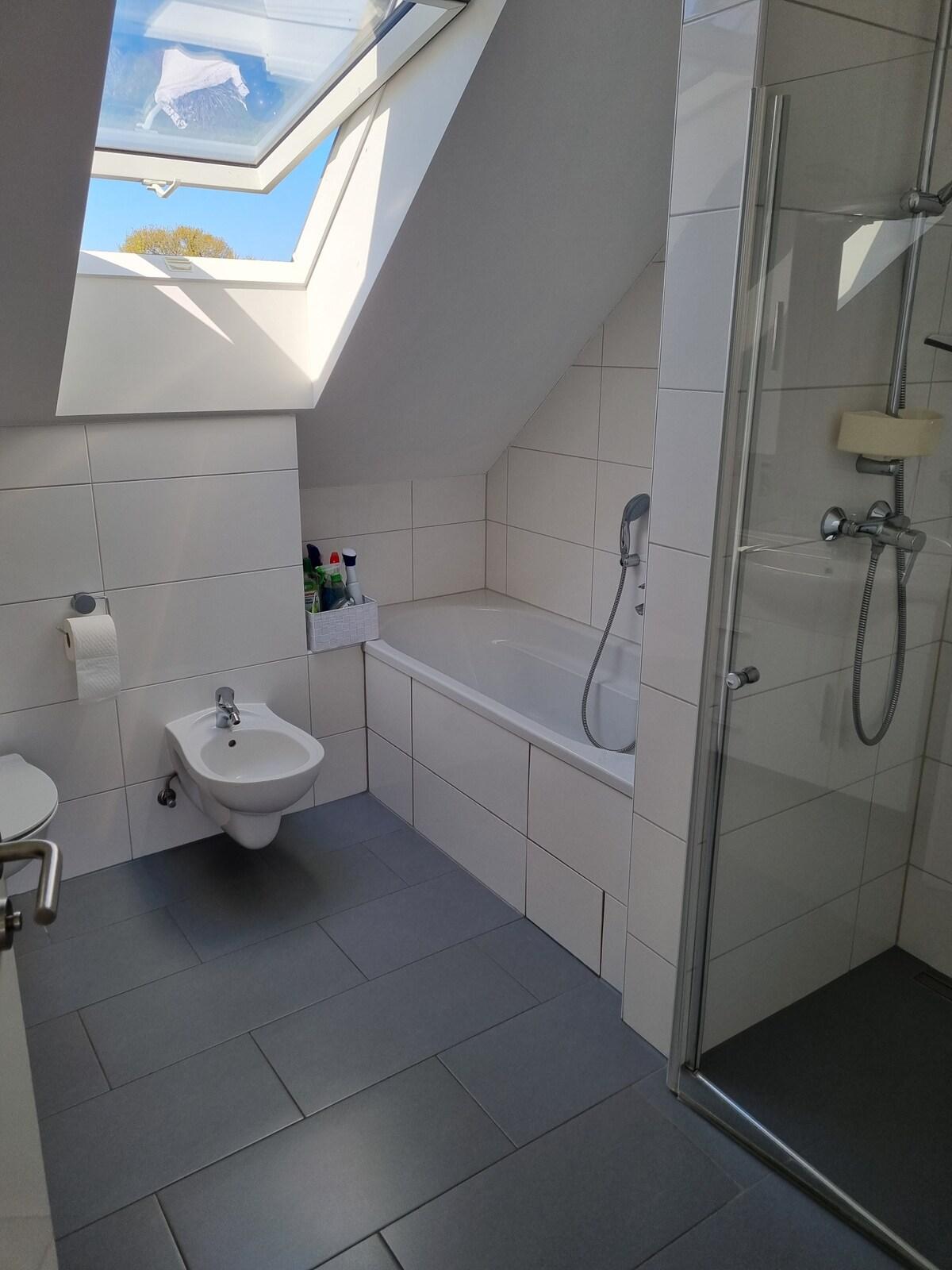 Badezimmer mit Badewanne und Dusche